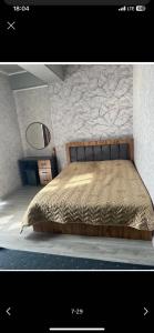 a bedroom with a bed with a stone wall at Likefront Apartment Issyk-Kul in Bosteri