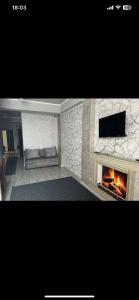 a living room with a fireplace and a flat screen tv at Likefront Apartment Issyk-Kul in Bosteri