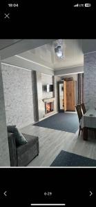 a living room with a couch and a table and a fireplace at Likefront Apartment Issyk-Kul in Bosteri