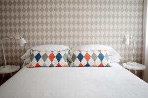 um quarto com uma cama com duas almofadas e uma parede em 60 Balconies Art em Madri