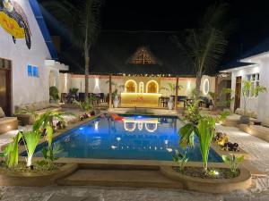 a pool at a hotel with palm trees in front of it at Kendwa Sky Hotel in Kendwa