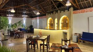 a restaurant with tables and chairs in a room at Kendwa Sky Hotel in Kendwa