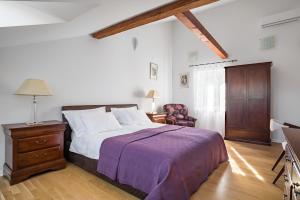 a bedroom with a large bed with a purple blanket at Penthouse Matkovic in Split