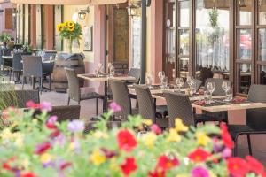 a restaurant with tables and chairs and flowers at Logis Hôtel-Restaurant du Mouton in Ribeauvillé