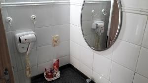 a bathroom with a sink, mirror, and toilet at Hotel Pousada da Mangueira in Salvador