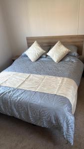 a bed with two pillows on it in a bedroom at Dawbers Retreat in Selsey +4 photos
