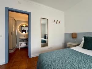 a bedroom with a bed and a sink and a mirror at O Monte da Estrada in Zambujeira do Mar +32 photos