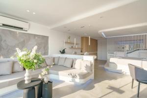 a living room with a white couch and a table at Kivotos Mykonos - Preferred Hotels & Resorts in Ornos