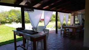 a patio with a table and chairs and curtains at Posada El Descanso in Mercedes