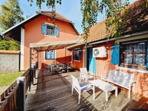 a wooden deck with chairs and a house at Terme Čatež - Family apartments with pool tickets in Čatež ob Savi