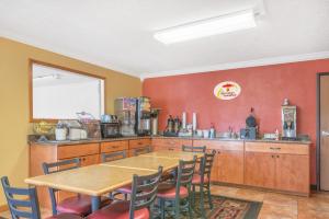 a kitchen with a table and chairs and a counter at Super 8 by Wyndham Vincennes in Vincennes