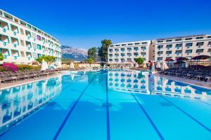 a swimming pool in front of two buildings at Daima Biz Hotel - Dolusu Aquapark Access in Kemer