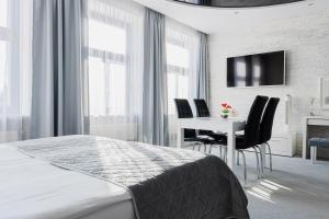 a bedroom with a bed and a table and chairs at Kamienica Pod Neptunem - Rynek Puck - Śniadanie w cenie - 200m do Molo in Puck