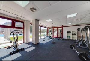 a gym with treadmills and ellipticals in a room with windows at Spa Valley II experiences Penthouse con Piscina climatizada y Yacuzzi in Villanueva de Río Segura