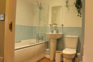 a bathroom with a toilet and a tub and a sink at The Contractor Condo - Underground Parking in Aylesbury +14 photos