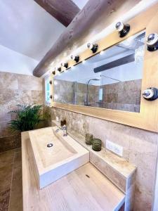 a bathroom with a sink and a large mirror at La petite fontaine in Bédoin +29 photos