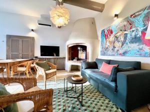 a living room with a blue couch and a dining room at La petite fontaine in Bédoin