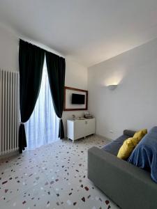 a living room with a couch and a large window at Convers'Amo Home in Conversano