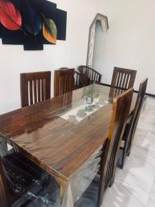 a wooden table with chairs and a dining room at Aamy Luxury Villa in Galle
