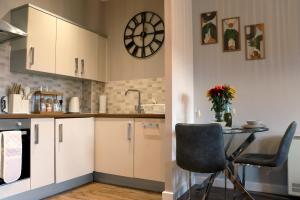 a kitchen with a table and a clock on the wall at The Contractor Condo - Underground Parking in Aylesbury