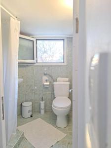 a bathroom with a toilet and a window at Perla in Pythagoreio +2 photos