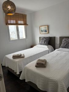 a bedroom with two beds with towels on them at Casa Aguila Ibiza in Cala Vadella +77 photos