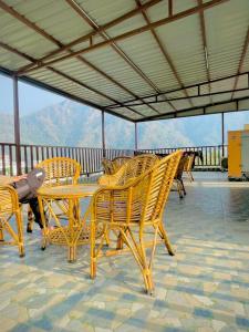 a group of wooden chairs and tables on a roof at Hotel Mount View Inn with terrace Ganga view- near Laxman jhula, Tapovan Rishikesh in Rishīkesh