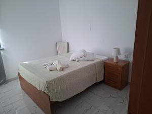 a bedroom with a bed with towels on it at Chambre Double dans spacieux appartement in Tarrafal