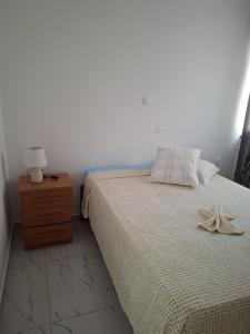 a bedroom with a bed and a nightstand with a flower on it at Chambre Double dans spacieux appartement in Tarrafal