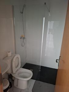 a small bathroom with a toilet and a shower at Chambre Double dans spacieux appartement in Tarrafal