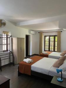 a hotel room with two beds and a piano at Kudaarala Heritage in Kengalla