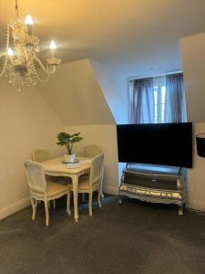 a dining room with a table and a large tv at Flat 2 Meadow view in Hurst