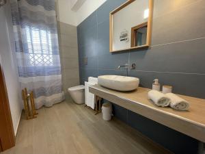 a bathroom with a sink and a toilet at Namastè Apartments Agrigento in Agrigento