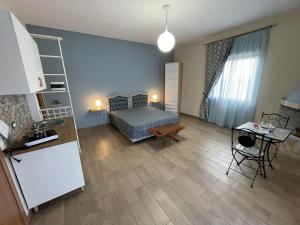 a room with a bed and a kitchen with a table at Namastè Apartments Agrigento in Agrigento
