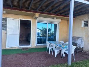a table and chairs under a pergola on a patio at Kaz Toutoune in Saint-Leu