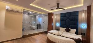 a bedroom with a large shower and a bed and a bed and a ceiling at Hotel Sunrise Muzaffarpur in Muzaffarpur