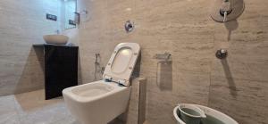 a bathroom with a toilet and a sink in it at Hotel Sunrise Muzaffarpur in Muzaffarpur