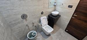 a bathroom with a toilet and a sink at Hotel Sunrise Muzaffarpur in Muzaffarpur +54 photos