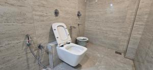 a bathroom with a toilet and a shower at Hotel Sunrise Muzaffarpur in Muzaffarpur
