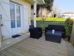 a patio with two chairs and a table on a porch at Au fil des mains in Le Houga