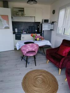 a living room with a table and chairs and a kitchen at Au fil des mains in Le Houga