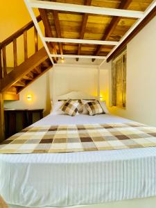 a bedroom with a large bed with a wooden ceiling at Ayubowan Home in Galle