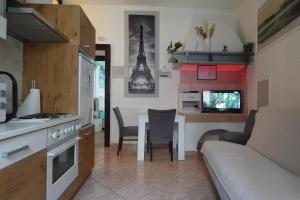 a kitchen and living room with a table and a couch at Red blue with private parking and Gray blue apartment in Pula