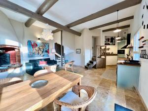 a living room with a wooden table and chairs at La petite fontaine in Bédoin