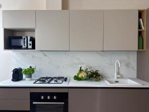 a kitchen with white cabinets and a sink and a stove at Tra i gussi in Imperia
