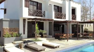 eine Villa mit Swimmingpool und ein Haus in der Unterkunft Maison D'hôtes Niokobokk in Ndiébène