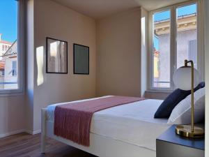 a bedroom with a bed and two windows at Tra i gussi in Imperia