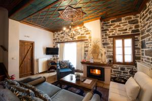 a living room with a couch and a fireplace at Archontiko Naoumidi in Portaria
