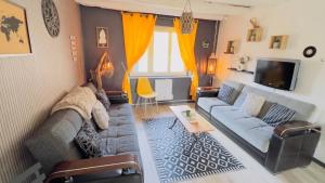 a living room with a couch and a tv at TOP HOST Les Perles des châteaux in Mer