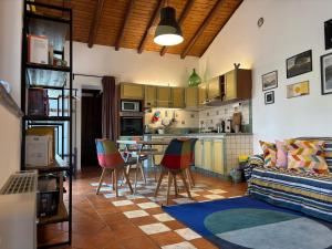 a living room with a couch and a kitchen at Soffio dell'Etna in Puntalazzo